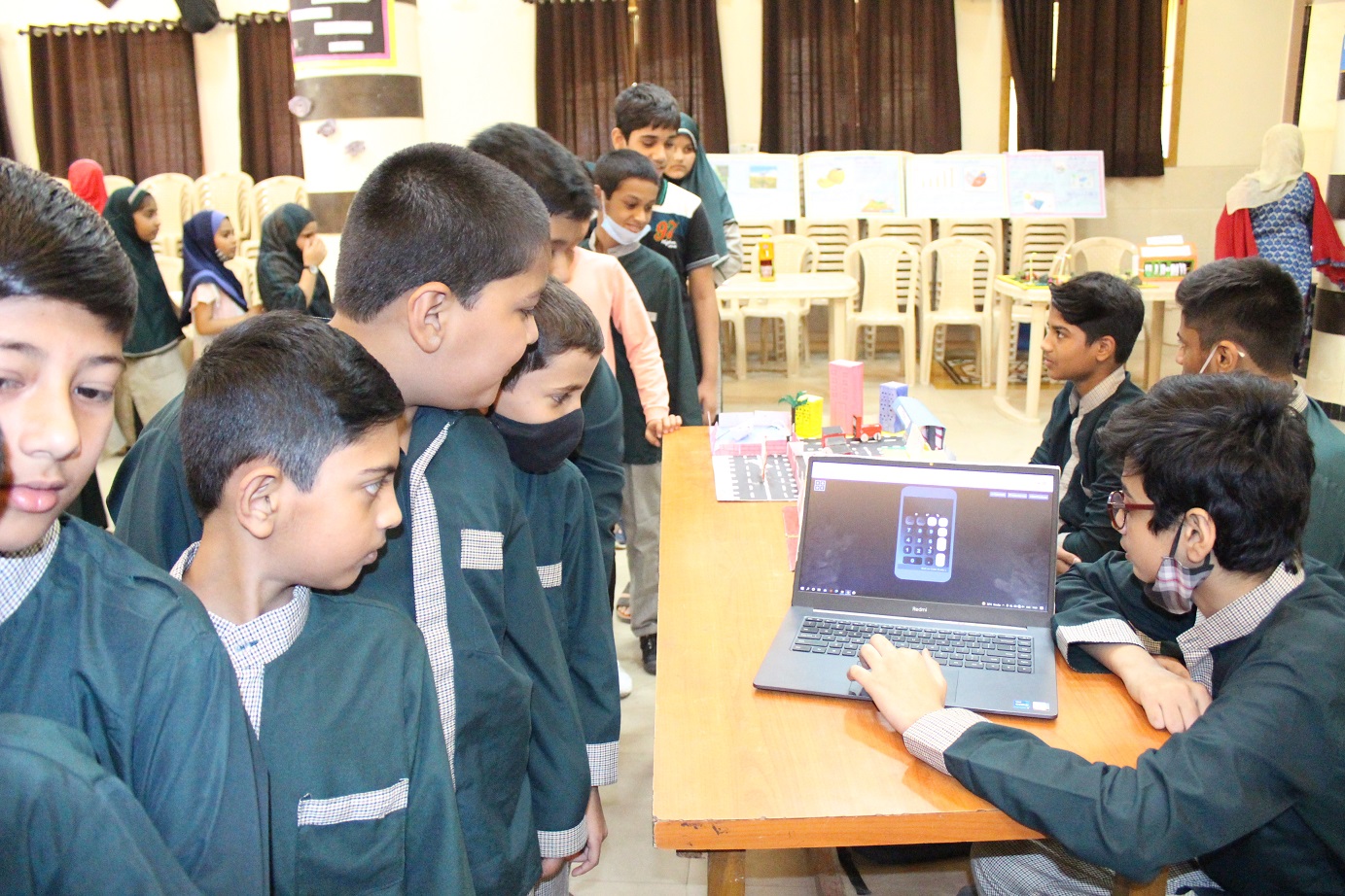 Students sharing a learning project on a laptop